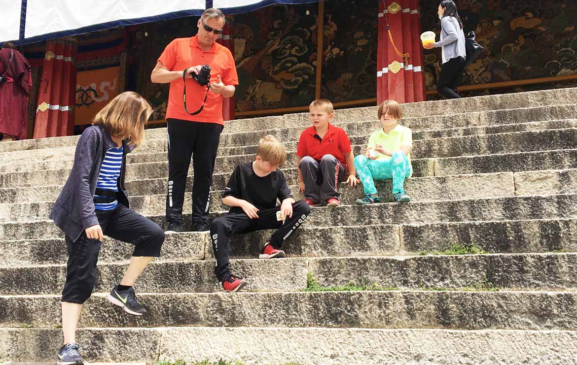 Family sightseeing at Drepung monastery. High altitude sickness in Tibet